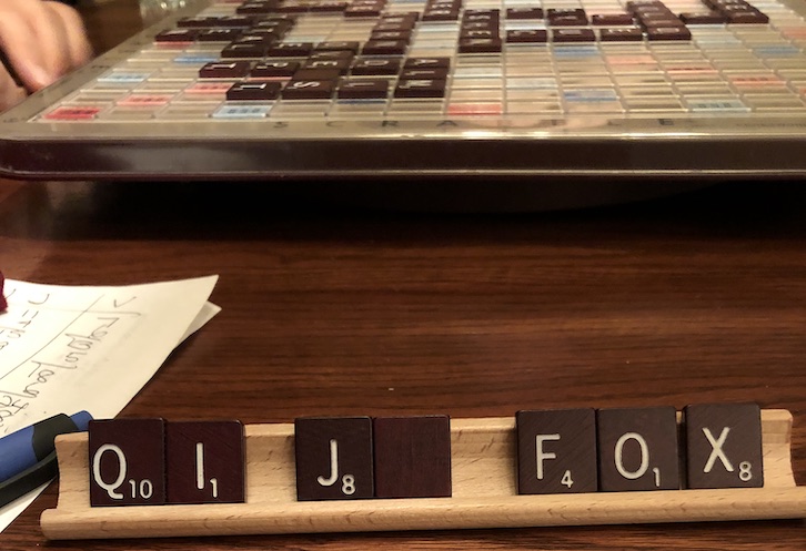Scrabble board and scrabble letters on a tray.