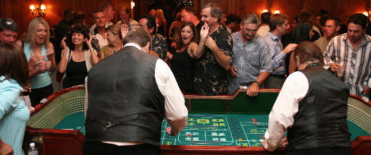 Craps dealers in the forground and players in the background.